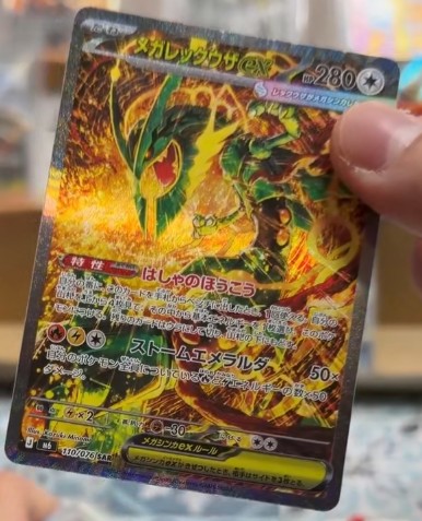 Leaked Mega Rayquaza ex Special Illustration Rare from Japan's Storm Emerald, showing the Pokémon coiled through a storm of gold and green energy