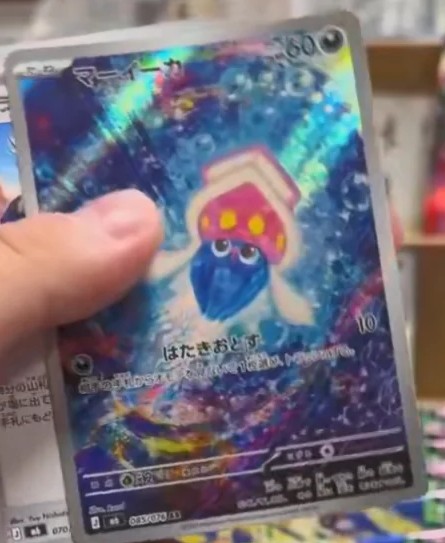 Leaked Inkay Illustration Rare from Storm Emerald, showing Inkay drifting inside a swirling blue and violet underwater vortex